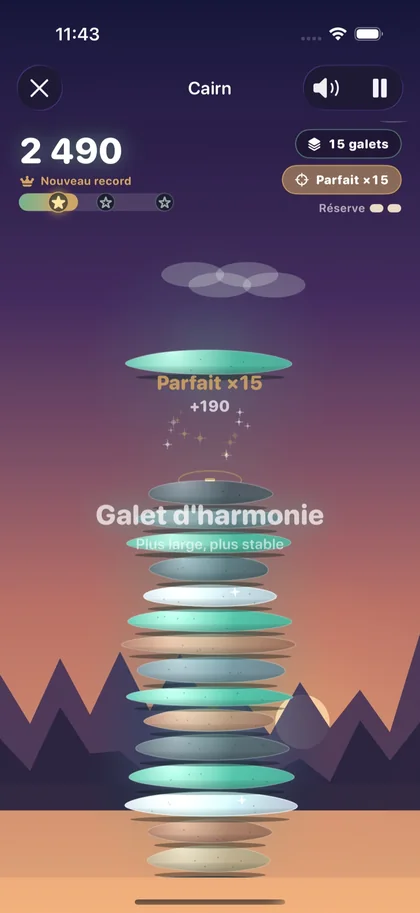 Jeu Cairn de Respire : galets empilés en équilibre devant des montagnes au crépuscule.