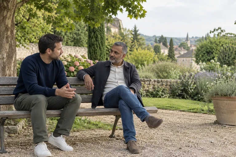 Deux hommes discutent sur un banc de jardin