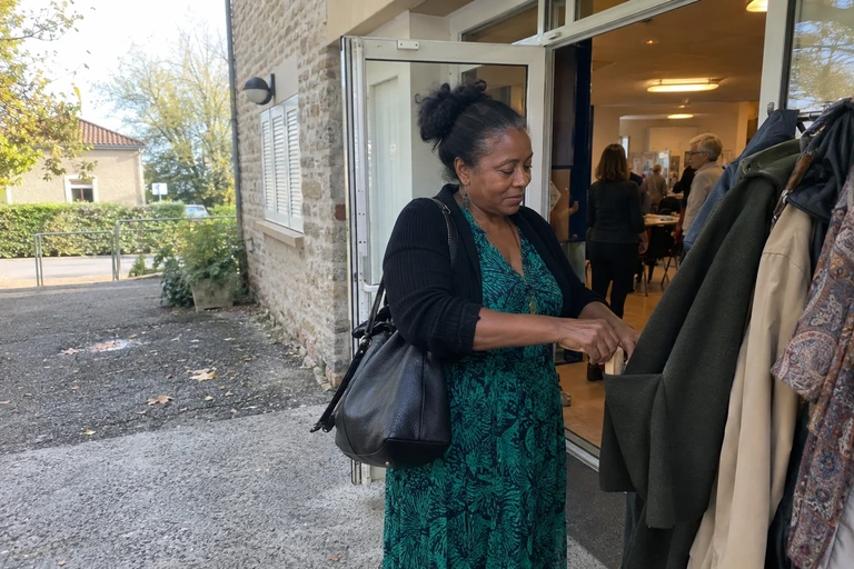 Une femme remet un petit objet en bois dans une poche