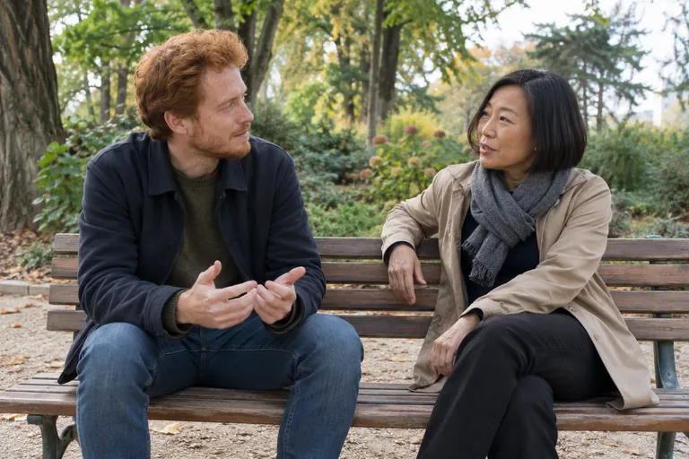 Un homme et une femme discutent sur un banc dans un parc