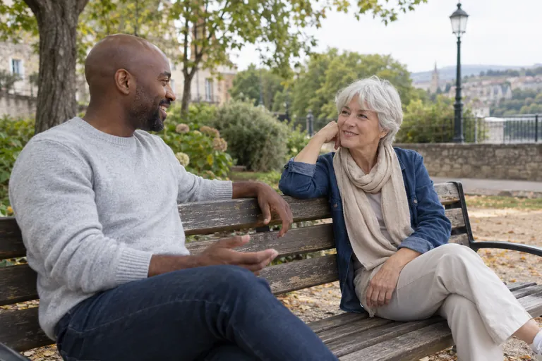 Un homme et une femme discutent sur un banc de parc