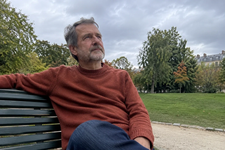 Un homme est assis sur un banc dans un parc