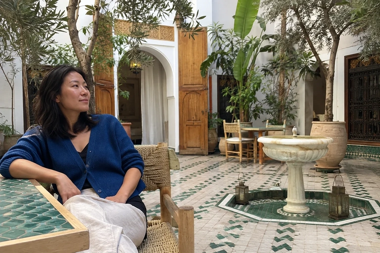 Une femme est assise dans une cour intérieure avec une fontaine