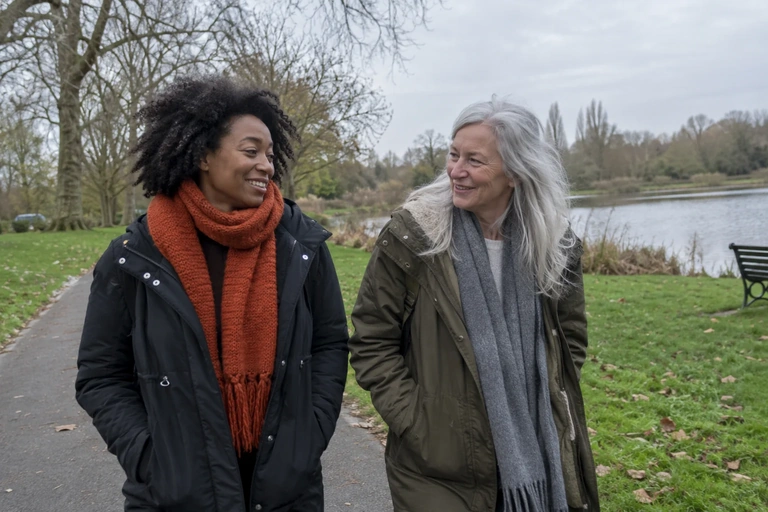 Deux femmes marchent dans un parc en matinée sous un ciel couvert