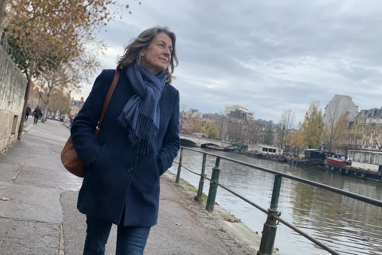 Une femme marche sur une promenade au bord d’un canal