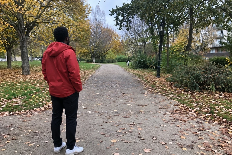 Un homme observe le départ d’une allée dans un parc urbain