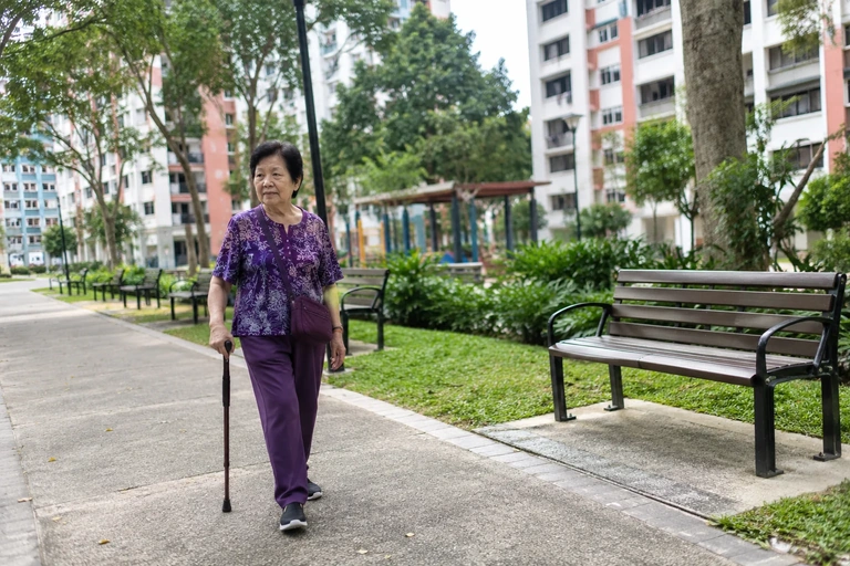 Une femme marche avec une canne sur une allée accessible