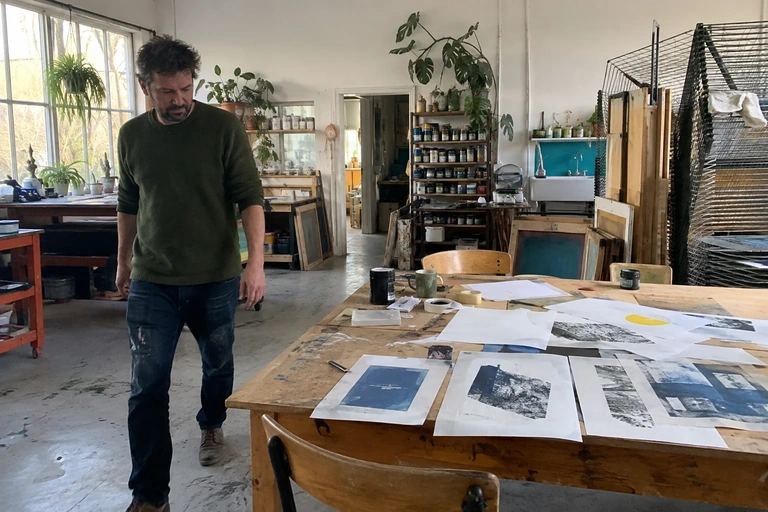 Un homme s’éloigne d’une table de brouillons dans un atelier