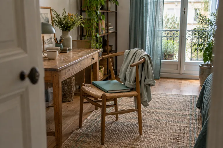 Une veste et un dossier reposent sur une chaise près d’un bureau