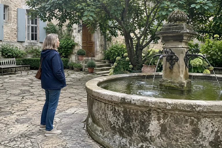 Une femme regarde une fontaine dans une cour paisible