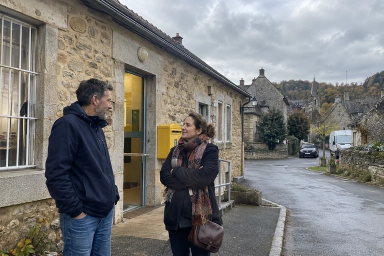 Deux adultes échangent dehors après une démarche dans un village