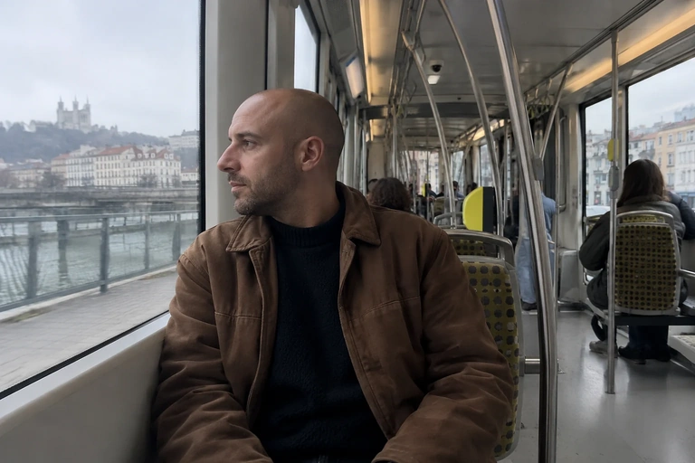 Un homme regarde dehors depuis une place assise dans un tram