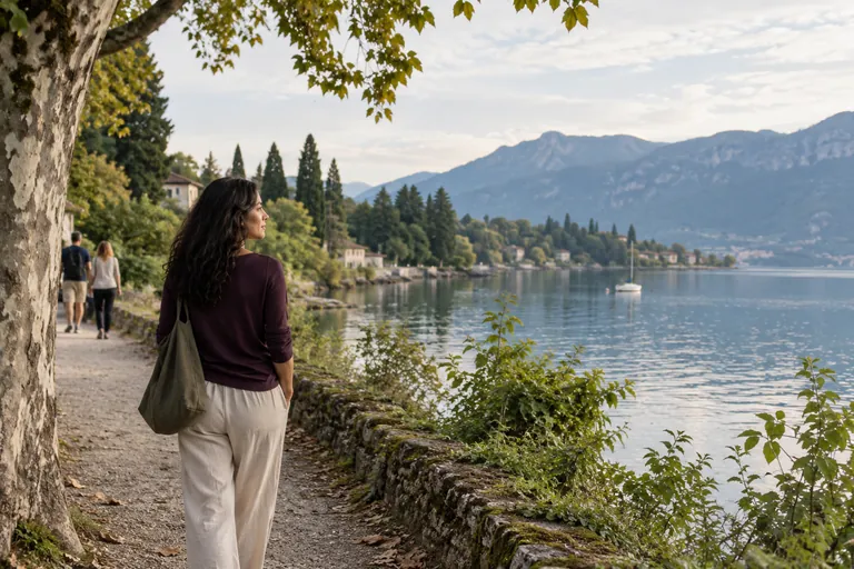Une femme en haut prune regarde un lac depuis un sentier